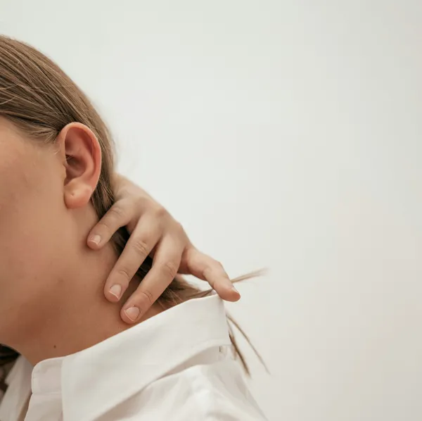 Person holder sig i nakken