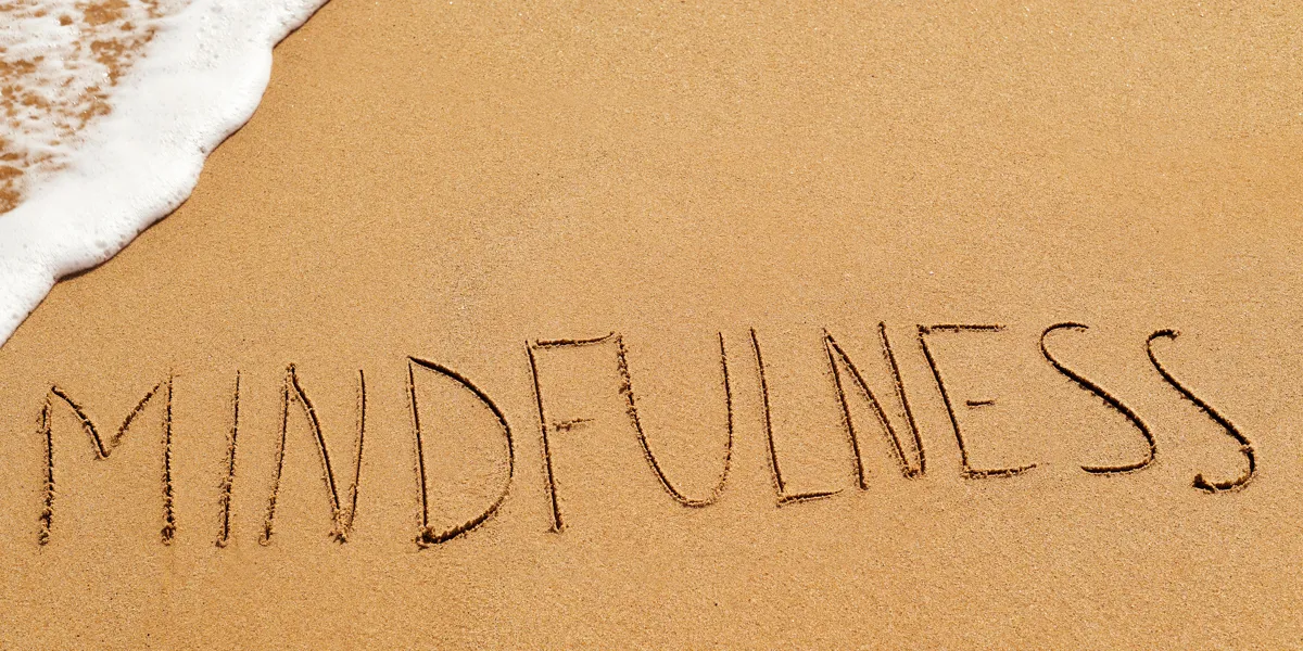 Mindfulness står skrevet på en sandstrand