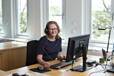 En dygtig medarbejder sidder klar til at hjælpe og rådgive dig.