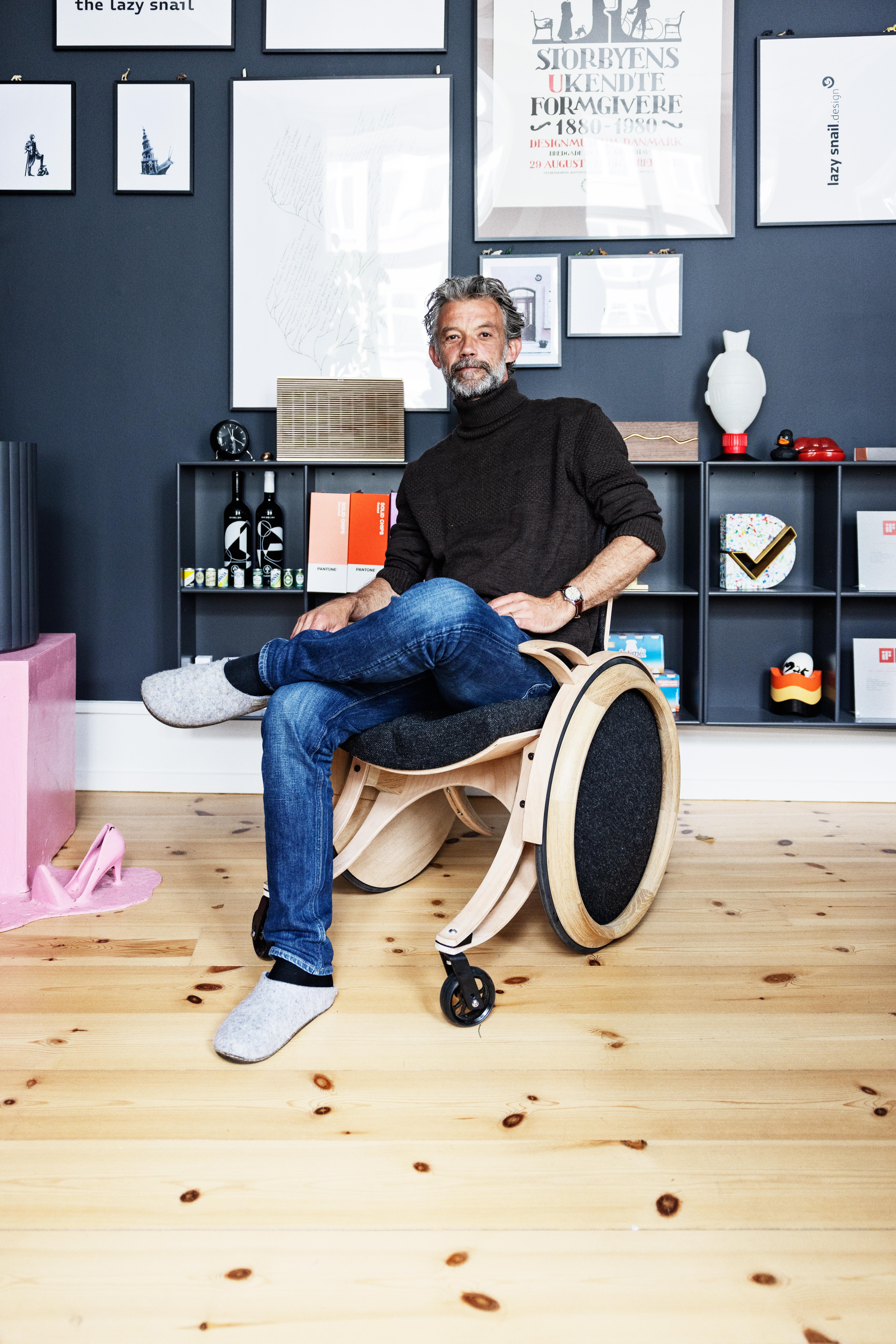 Designeren Sophus Bang sidder i hans selvdesignede koerestol