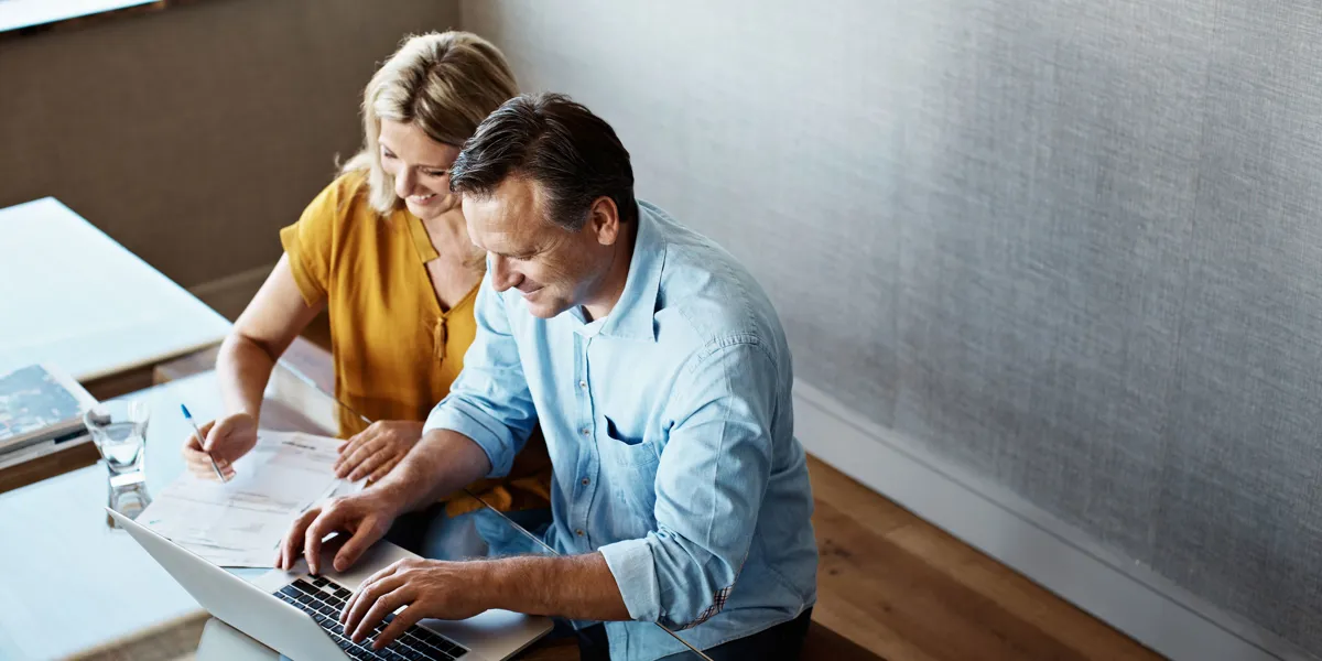 Kvinde og mand sidder og arbejder ved computer.