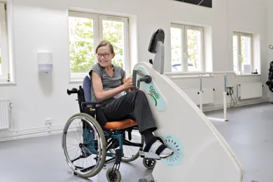 En patient sidder ved en maskine i traeningscentret i Roedovre.