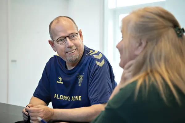 To personer sidder og taler sammen