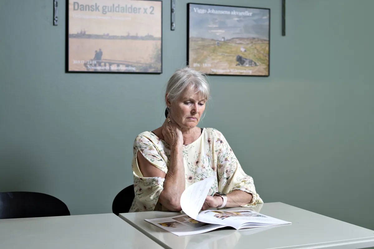 En borger sidder og læser UlykkesPatientForeningens folder