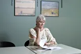 En borger sidder og laeser UlykkesPatientForeningens magasin