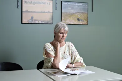 En borger sidder og laeser UlykkesPatientForeningens magasin