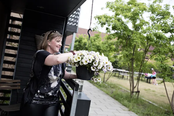 En kvinde vander sine blomster