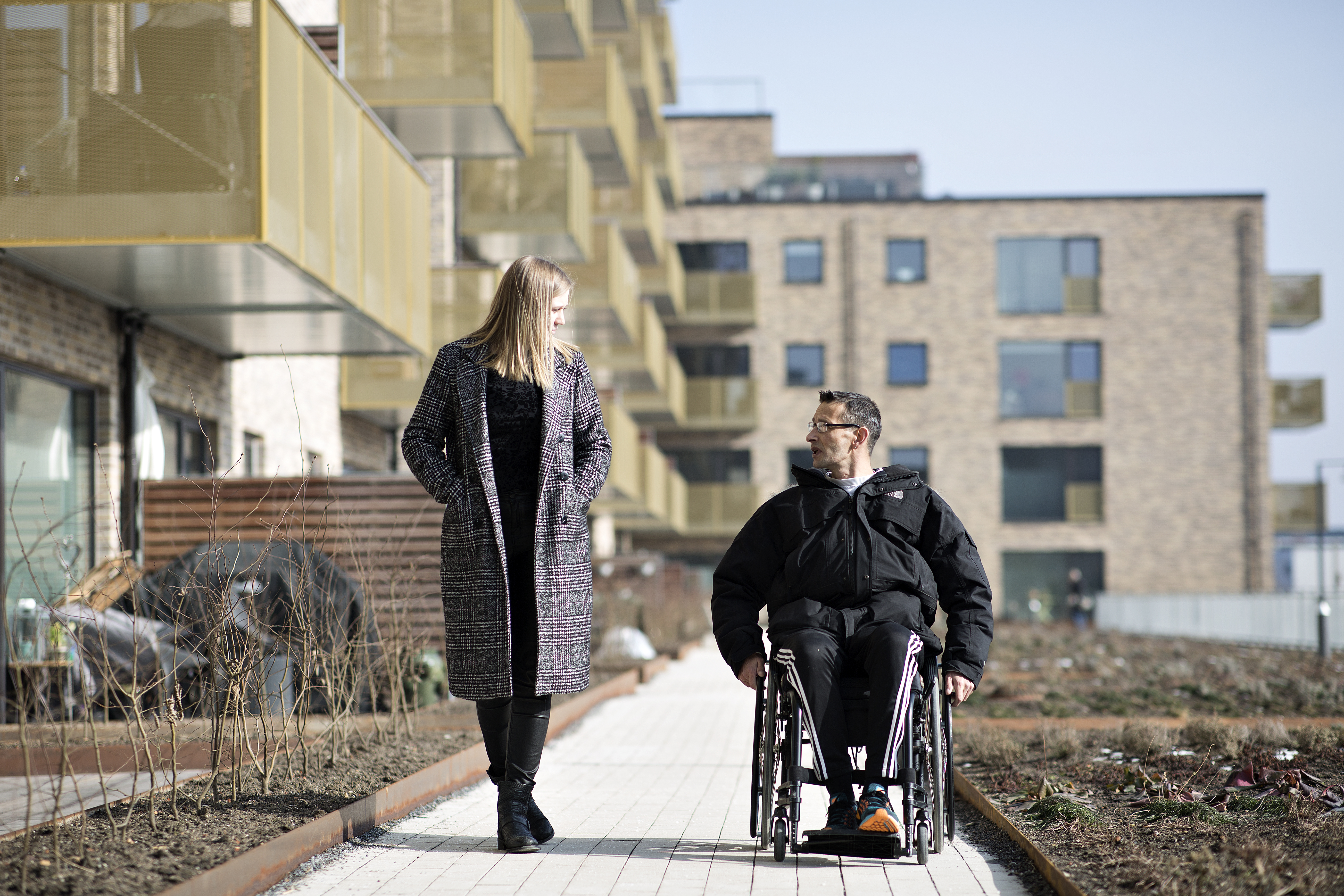 En borger/patient i koerestol med en personlig og praktisk hjaelper