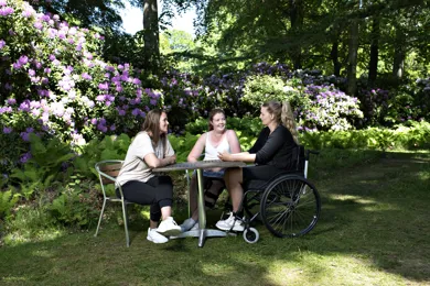 Tre kvinder sidder og taler sammen rundt om et bord