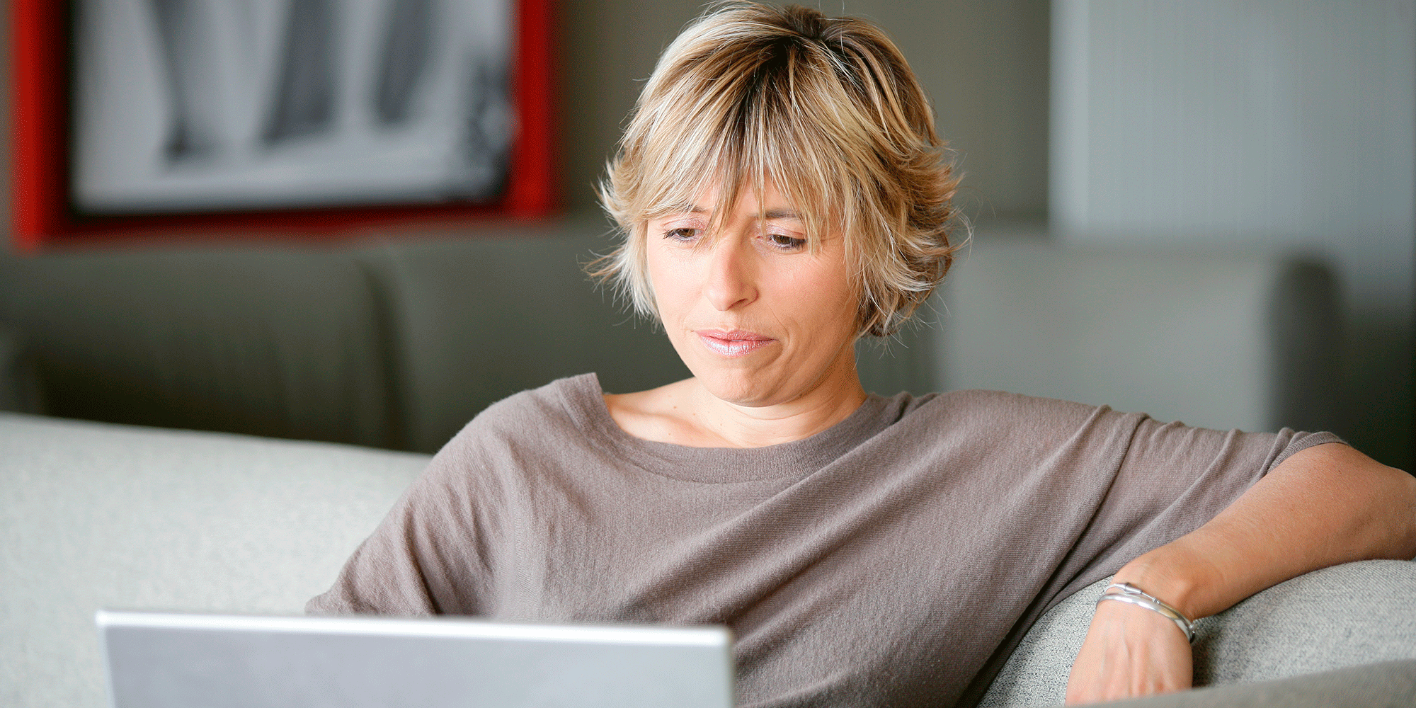 Kvinder sidder i sofa med en computer