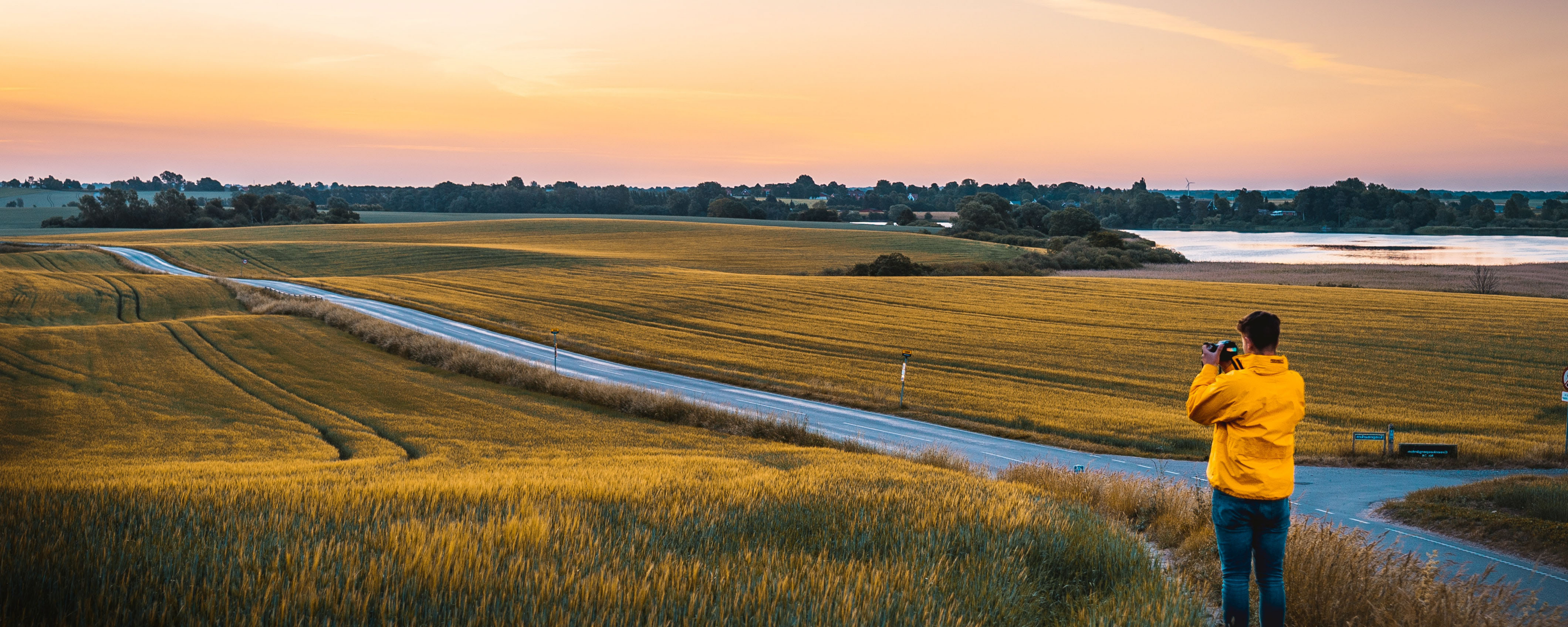 Mand tager billeder ved en mark og sø