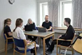 En patient/borger sidder sammen med et dygtigt team af faglaerte