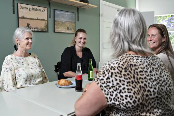 Fire kvinder hygger sig med en sodavand og kage