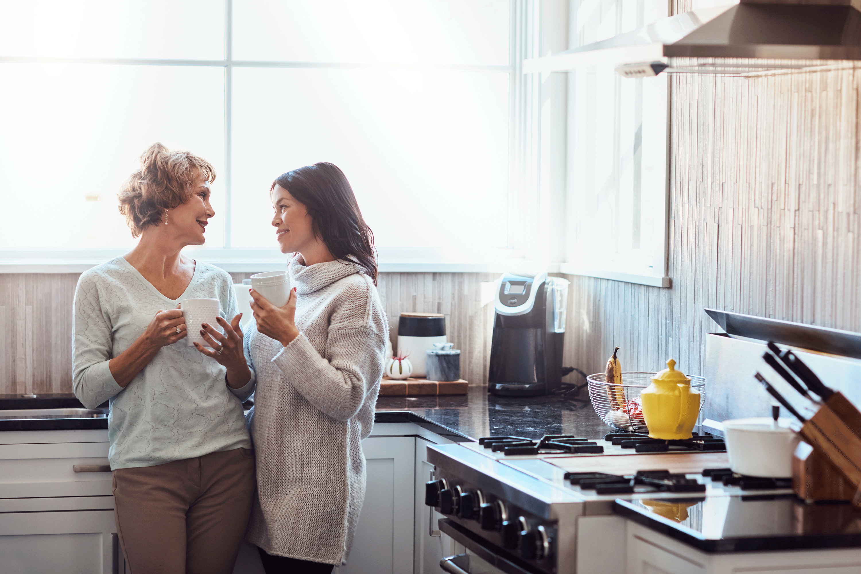 To kvinder der snakker sammen i et køkken
